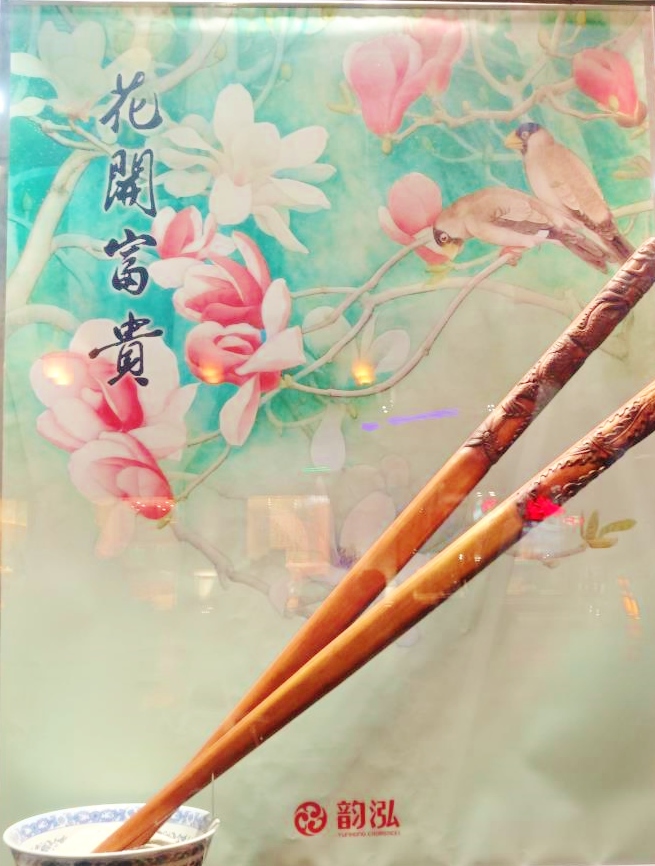 Capitalism and traditional culture inter-mix in China's urban cities as symbolically Chinese images of traditionally carved wooden chopsticks, a china rice bowl combined with Chinese calligraphy and art are displayed in shop windows everywhere in an attempt to effectively 'cash-in on culture'. 