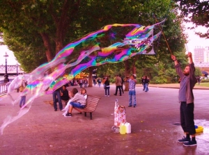 A street performer conjures his liquid magic on the Thames riverside to a bike-mad crowd.