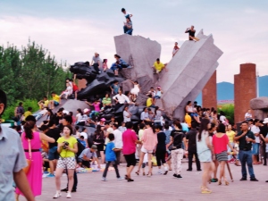 Tourists congregate like camera-laden locusts for summer celebrations in Liangshang Yi.